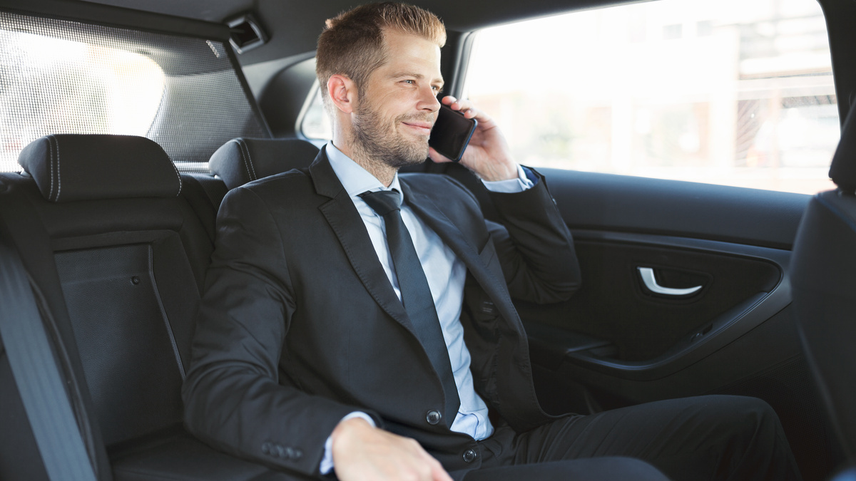 homme d'affaires téléphonant à l'arrière d'un véhicule